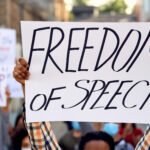 Close-up of protester holding freedom of speech sign.