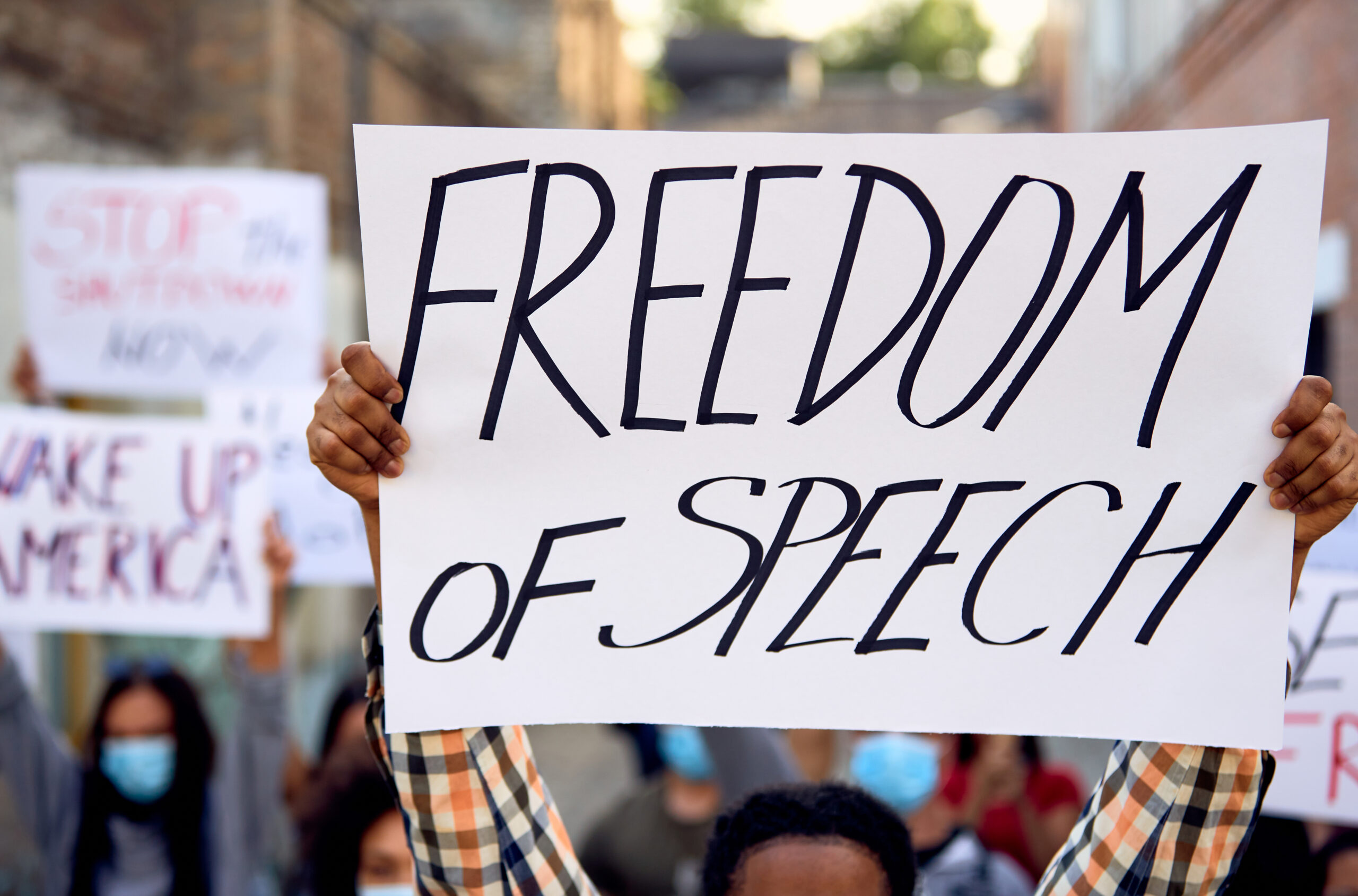 Close-up of protester holding freedom of speech sign.