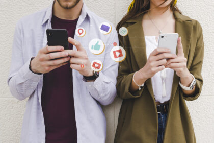 Two people holding cell phones with social media icons indicating social media use