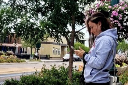 Woman standing looking at cell phone