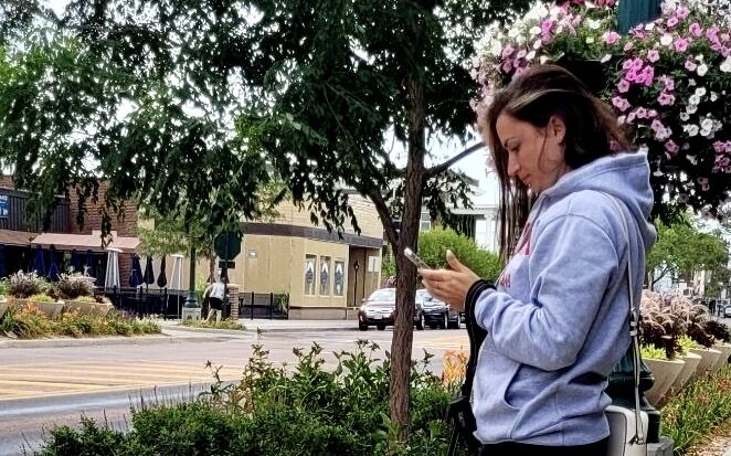 Woman standing looking at cell phone